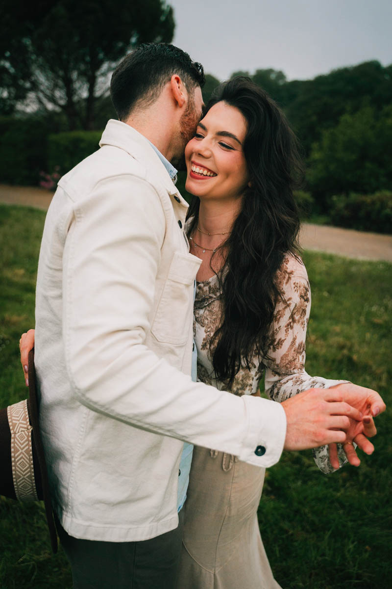 a woman smiles as her partner whispers in her ear