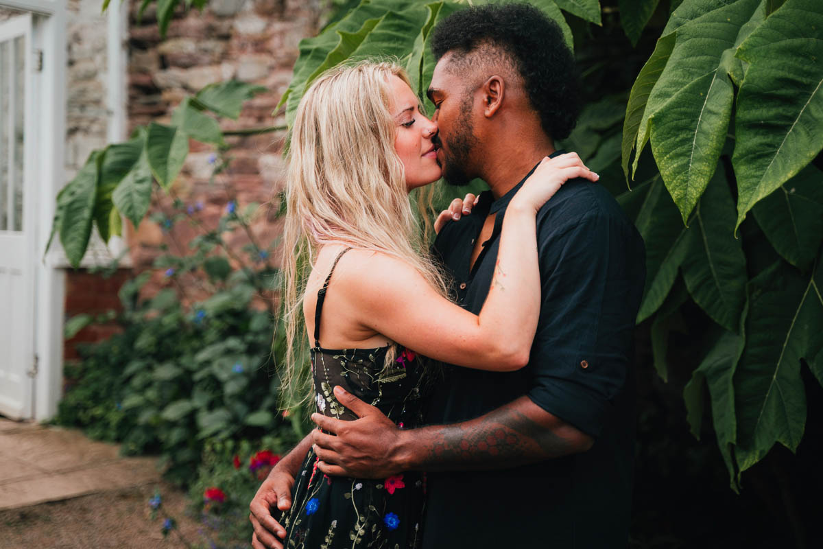 a man leans in for a kiss from his fiance