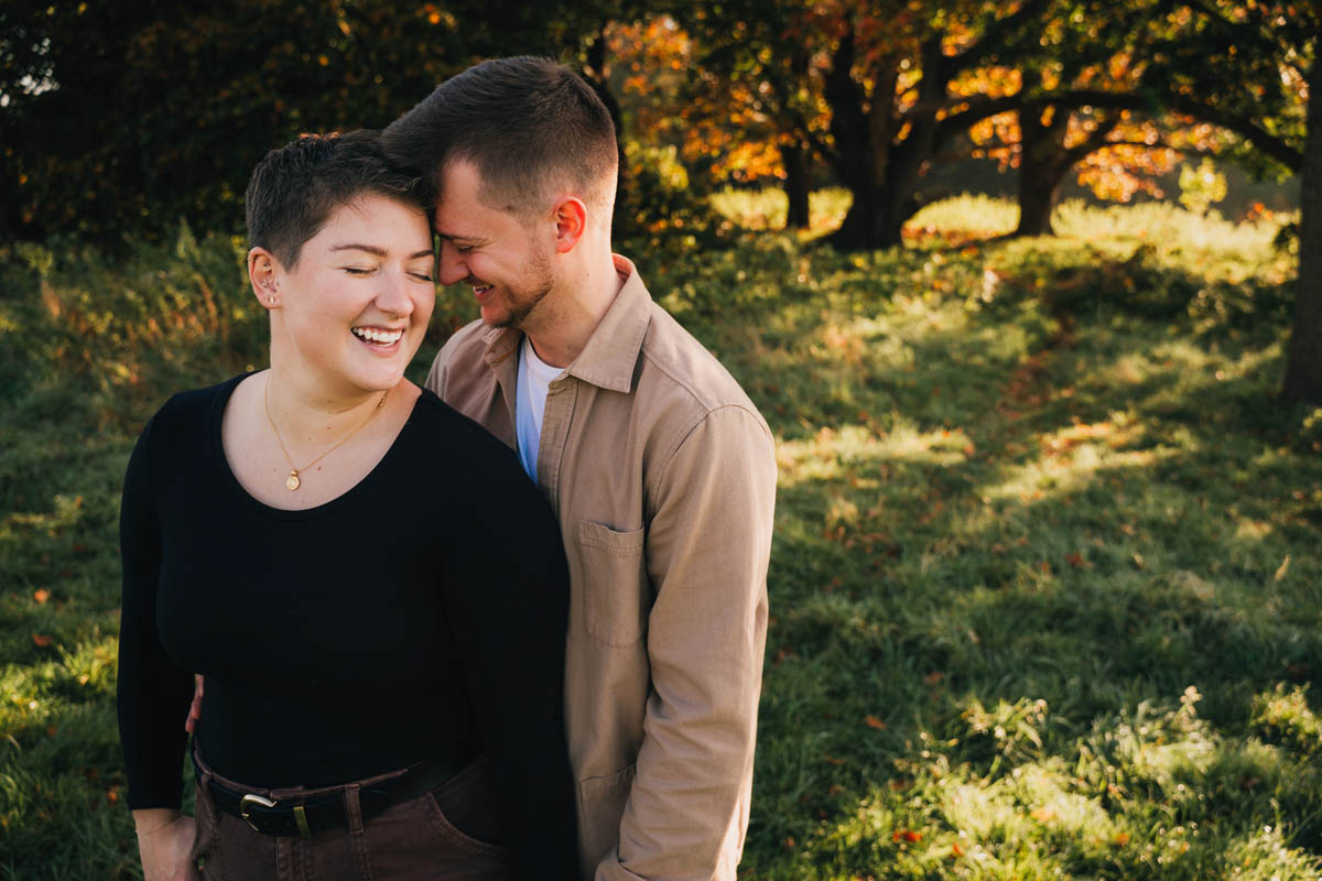 two partners rest their foreheads together and hold hands