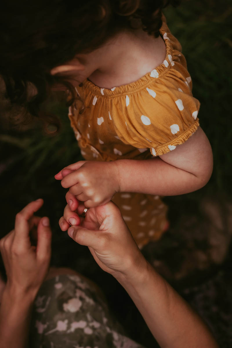 a child holds their mother's hand