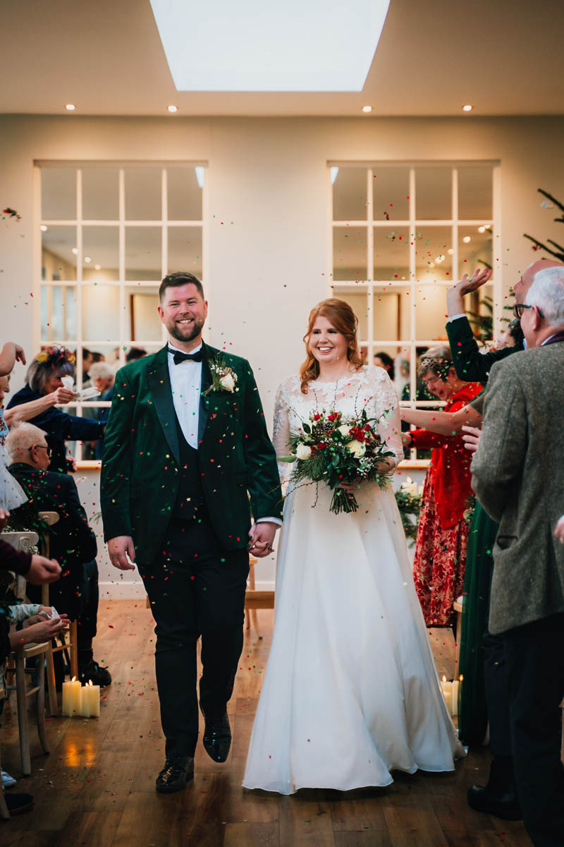 guests throw confetti over a bride and groom