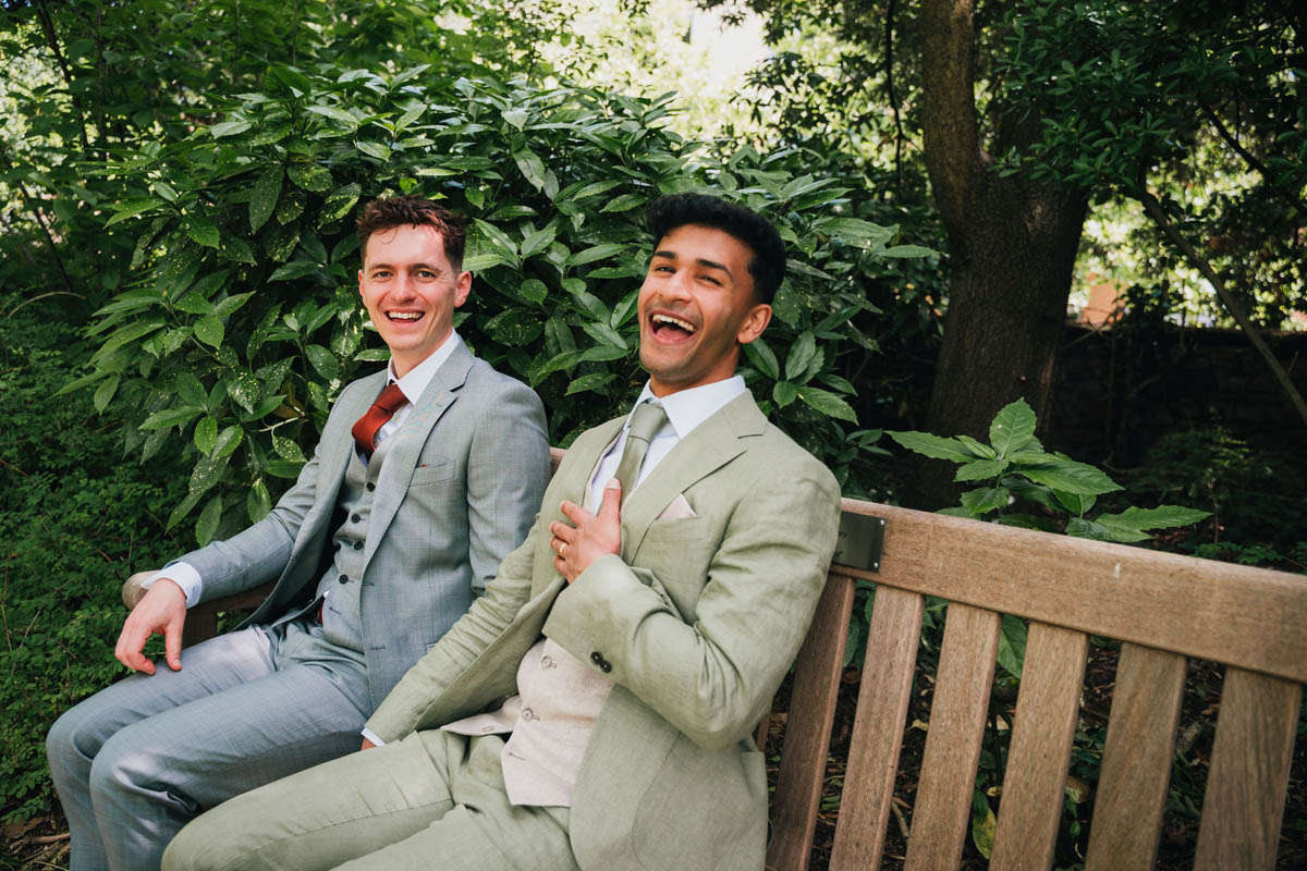 two grooms laugh at the camera