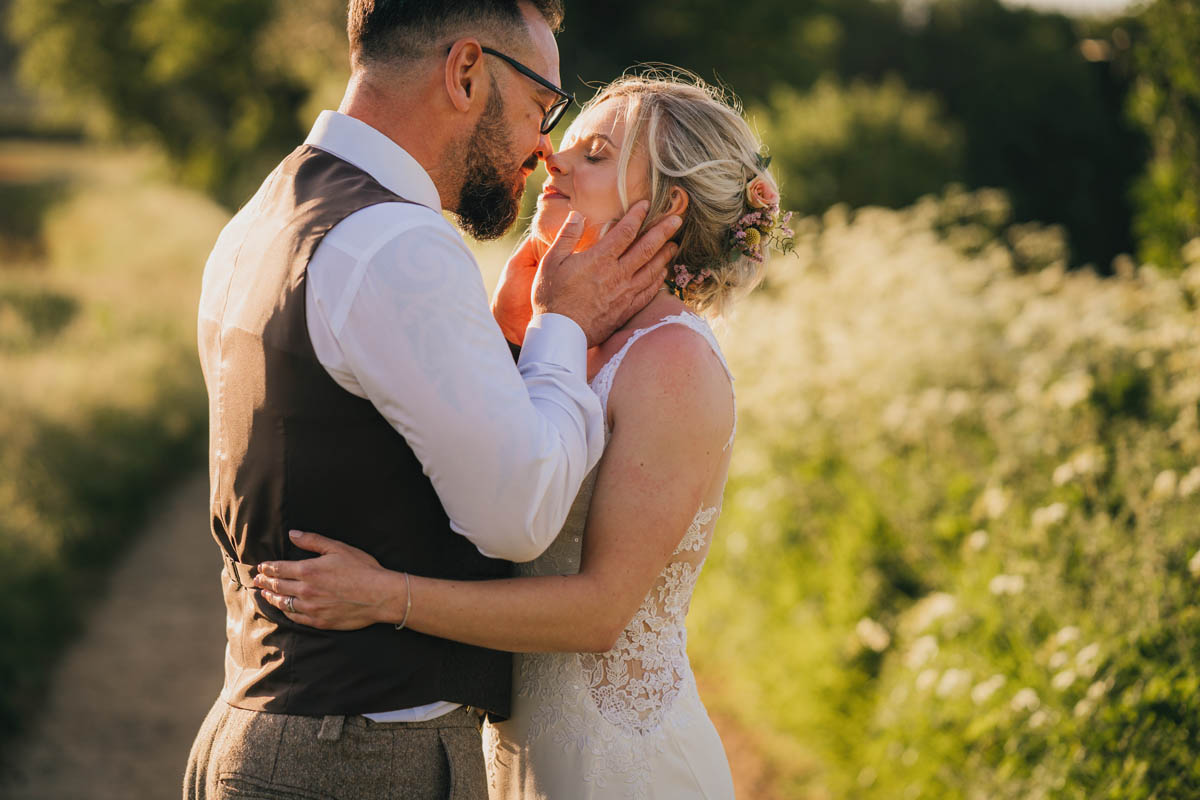 a man holds his wife in an intimate embrace at golden hour