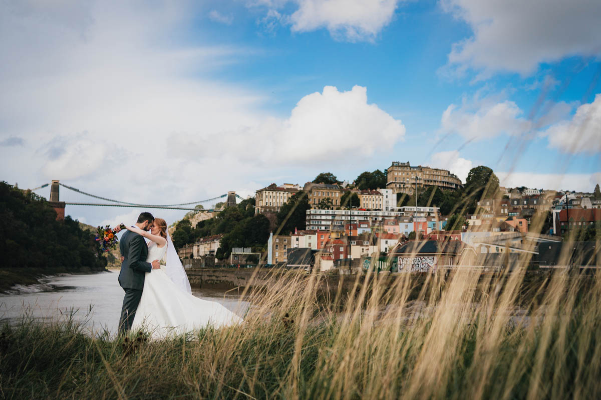 the painswick hotel in the background and two brides in white wedding dreses walking away from the camera 