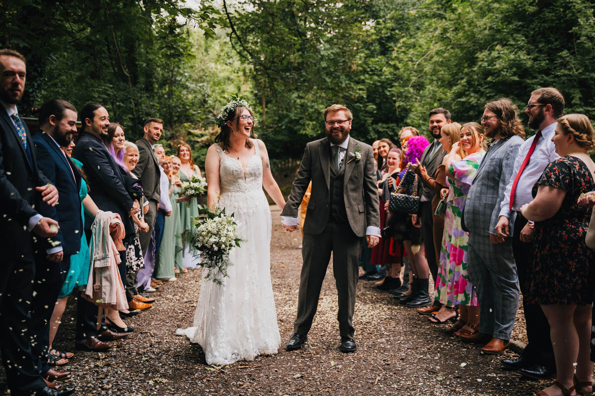 a couple hold hands and laugh on their wedding day