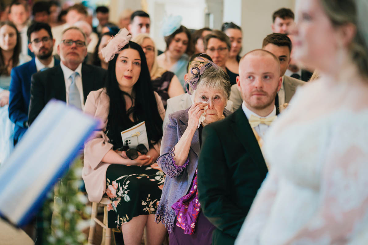 an older lady wipes away a tear and guests look emotion