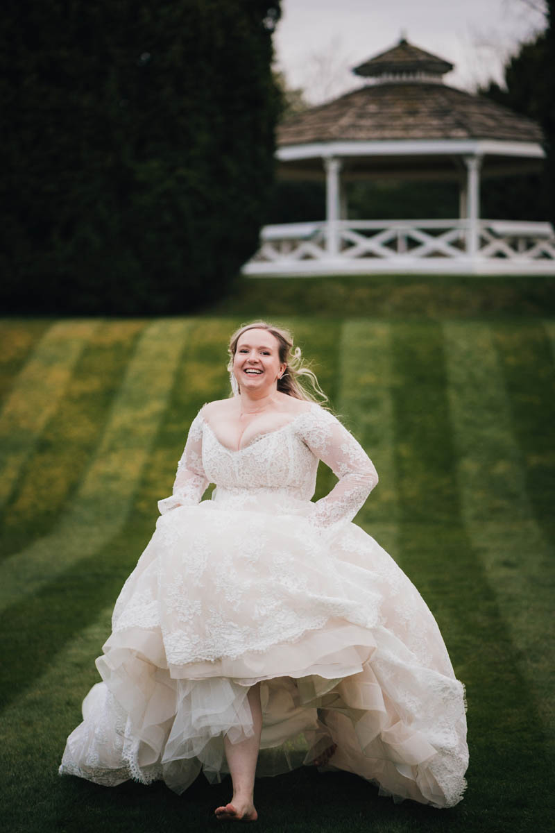 a bride runs down a well manicured lawn