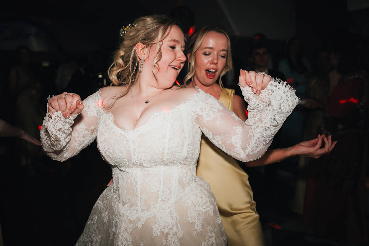 a bride and her bridesmaid dance